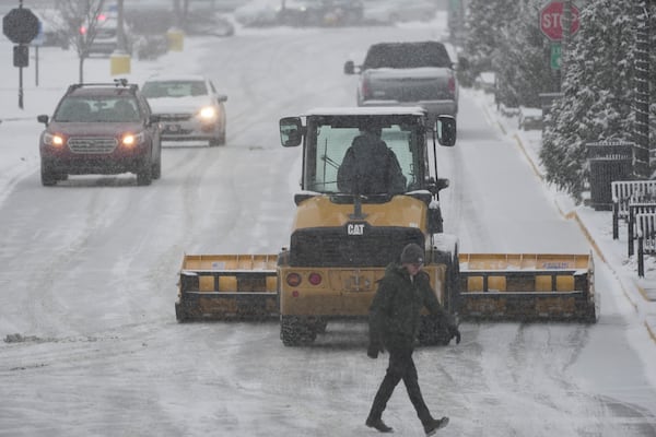 A plow clears a parking lot during a winter storm, Sunday, Jan. 5, 2025, in Cincinnati. (AP Photo/Joshua A. Bickel)