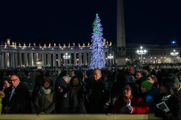 Faithful and pilgrims wait in St. Peter's Square for the opening of the holy door of St. Peter's Basilica at The Vatican, Tuesday, Dec. 24, 2024, marking the start of the Catholic jubiliar year 2025. (AP Photo/Gregorio Borgia)