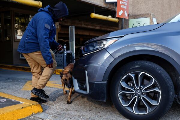 Security and bomb sniffing dogs check vehicles as they enter the Superdome parking garage ahead of the Sugar Bowl NCAA College Football Playoff game, Thursday, Jan. 2, 2025, in New Orleans. (AP Photo/Butch Dill)