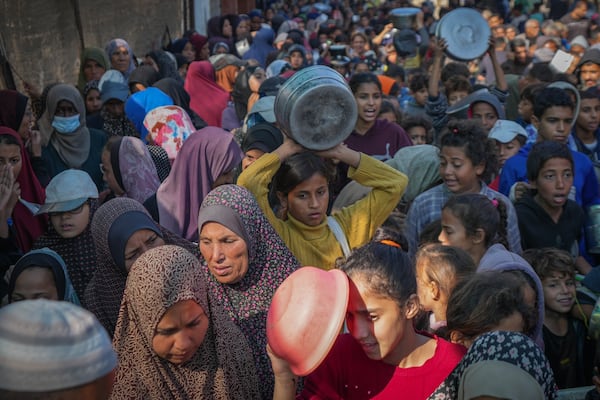 Palestinian children queue for donated food in Deir al-Balah, Gaza Strip, Friday Nov. 22, 2024. (AP Photo/Abdel Kareem Hana)