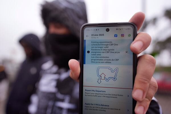 A migrant seeking asylum holds up the CBP One app showing his appointment was canceled after President Donald Trump was sworn into office, Monday, Jan. 20, 2025, in Matamoros, Mexico. (AP Photo/Eric Gay)