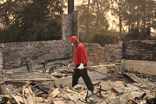 A man searches though his destroyed home after the Eaton Fire in Altadena, Calif., Thursday, Jan. 9, 2025. (AP Photo/Nic Coury)