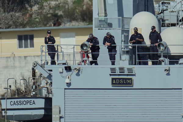 Crew members of the Italian Navy ship Cassiopea watch the disembarkation of 49 migrants to Albania for processing following earlier court rejections to Albania, in the port of Shengjin, northwestern Albania, Tuesday, Jan. 28, 2025. (AP Photo/Vlasov Sulaj)