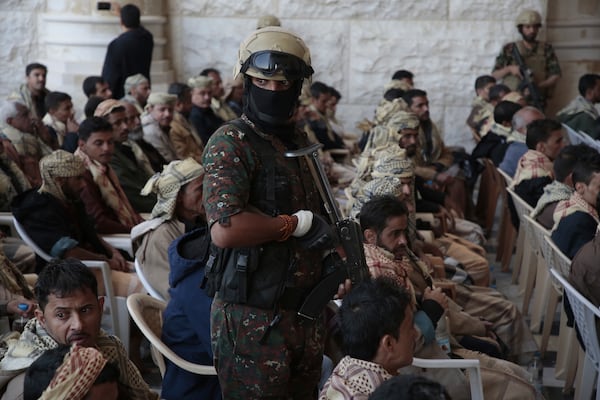 A Houthi soldier escorts released prisoners loyal to the Yemeni government after their release, in Sanaa, Yemen, Saturday, Jan. 25, 2025. (AP Photo/Osamah Abdulrahman)