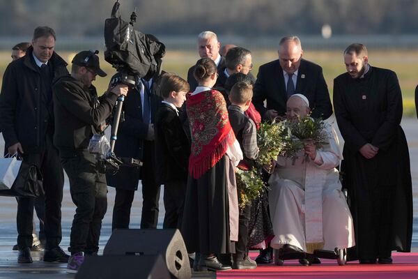 Pope Francis is welcomed by children as he arrives at Ajaccio International Airport on the occasion of his one-day visit in the French island of Corsica, Sunday, Dec. 15, 2024. (AP Photo/Alessandra Tarantino)