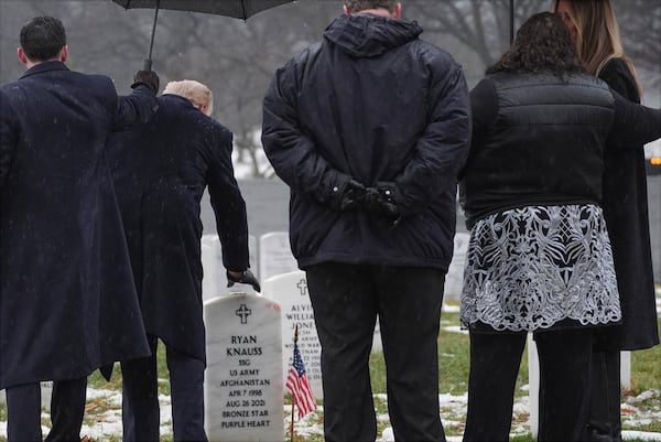 President-elect Donald Trump touches the headstone of Army Staff Sgt. Ryan Christian Knauss during a visit to Section 60 at Arlington National Cemetery, Sunday, Jan. 19, 2025, in Arlington, Va. (AP Photo/Evan Vucci)