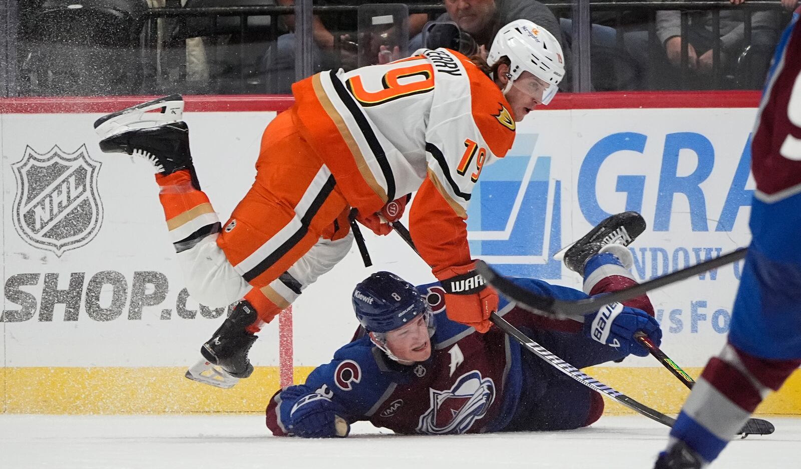 Anaheim Ducks right wing Troy Terry, top, jumps over Colorado Avalanche defenseman Cale Makar, bottom, in pursuit of the puck in overtime of an NHL hockey game Friday, Oct. 18, 2024, in Denver. (AP Photo/David Zalubowski)