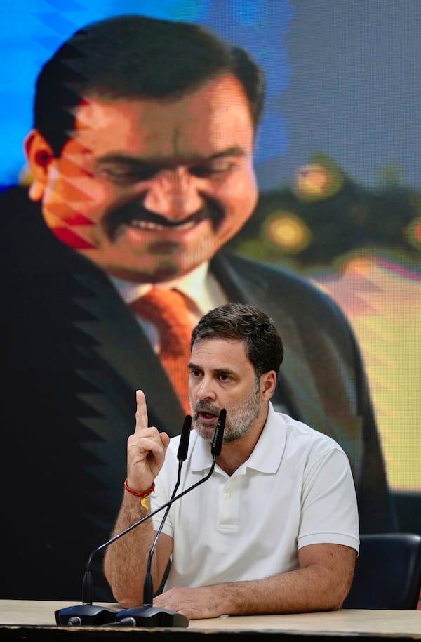 India's opposition Congress party leader Rahul Gandhi, addresses the media on Indian businessman Gautam Adani, after Adani was indicted by U.S. prosecutors on charges he duped investors in a massive solar energy project in India, in New Delhi, India, Thursday, Nov. 21, 2024. An image of Adani is behind. (AP Photo/Manish Swarup)