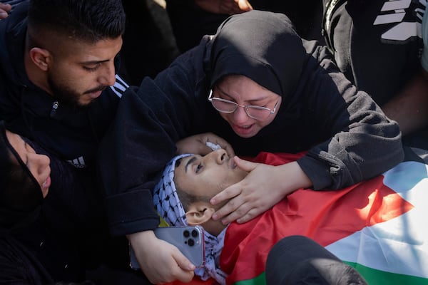 Relatives mourn over the body of Palestinian Muhammad Abu Amer, 18, who was killed at night during an Israeli army raid at his funeral in the West Bank refugee camp of Balata, Nablus, Saturday, Jan. 4, 2025. (AP Photo/Majdi Mohammed)