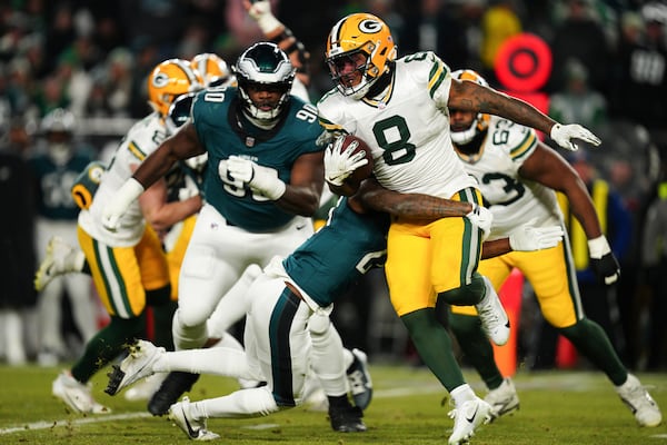 Green Bay Packers running back Josh Jacobs (8) is tackled by Philadelphia Eagles cornerback Quinyon Mitchell (27) during the second half of an NFL wild-card playoff football game Sunday, Jan. 12, 2025, in Philadelphia. (AP Photo/Derik Hamilton)