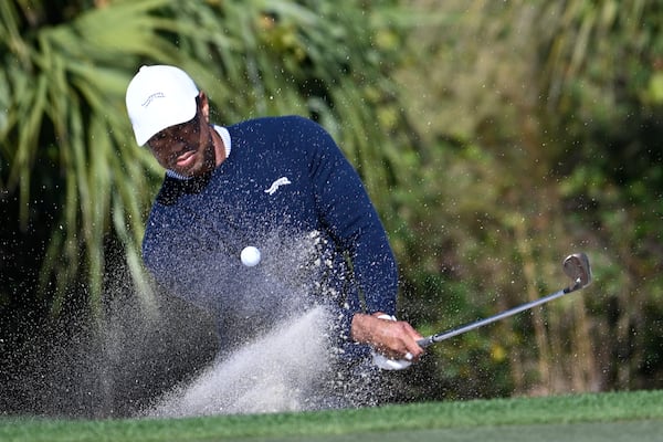 Tiger Woods hits out of a bunker onto the fourth green during the first round of the PNC Championship golf tournament, Saturday, Dec. 21, 2024 in Orlando. (AP Photo/Phelan M. Ebenhack)