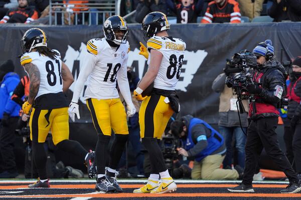 Pittsburgh Steelers tight end Pat Freiermuth (88) celebrates with wide receiver Mike Williams (18) after scoring a touchdown against the Cincinnati Bengals during the second half of an NFL football game Sunday, Dec. 1, 2024, in Cincinnati. (AP Photo/Joshua A. Bickel)