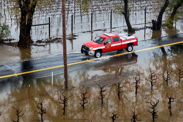 A firefighter drives past flooded vineyards as heavy rains continue in Windsor, Calif., Friday, Nov. 22, 2024. (Photo by Noah Berger)