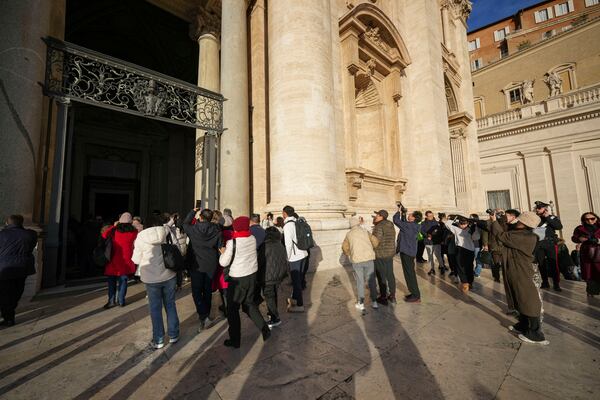 Faithful arrive to walk through the Holy Door of St.Peter's Basilica at the Vatican, Wednesday, Dec. 25, 2024, after it was opened by Pope Francis on Christmas Eve marking the start of the Catholic 2025 Jubilee. (AP Photo/Andrew Medichini)