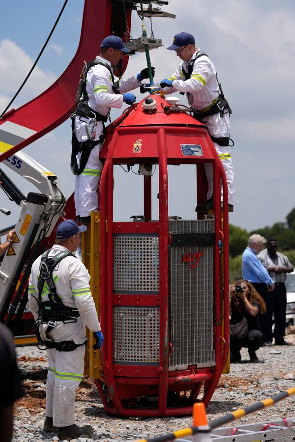 Mine rescue workers work on a cage that was used to rescue trapped miners at an abandoned gold mine, where miners were rescued from below ground, in Stilfontein, South Africa, Thursday, Jan. 16, 2025. (AP Photo/Themba Hadebe)