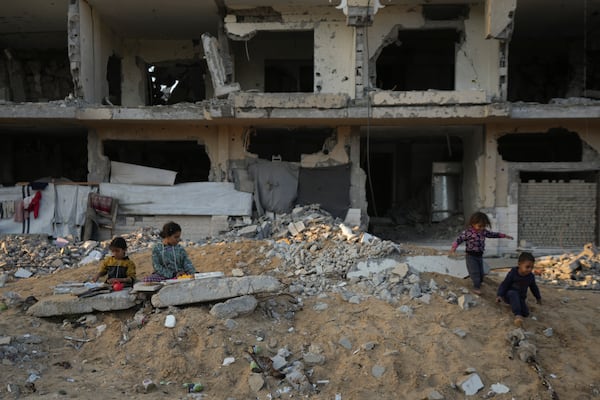 Palestinian children play on the rubble of destroyed buildings at a neighbourhood in Khan Younis, Gaza Strip, Sunday, Dec. 1, 2024. (AP Photo/Abdel Kareem Hana)