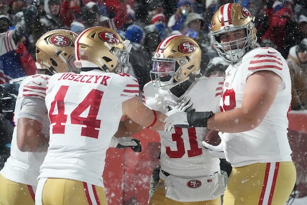 San Francisco 49ers running back Isaac Guerendo, second from right, is congratulated by teammates after scoring against the Buffalo Bills during the second half of an NFL football game in Orchard Park, N.Y., Sunday, Dec. 1, 2024. (AP Photo/Gene J. Puskar)