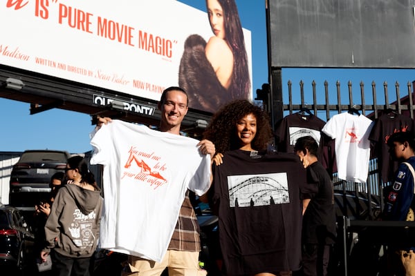 Van Tillian, left and Kapri Matlock pose for a photo with tee-shirts they got at a Pop-Up merchandise event for the movie Anora on Saturday, Nov. 9, 2024 in Los Angeles. (AP Photo/Richard Vogel)