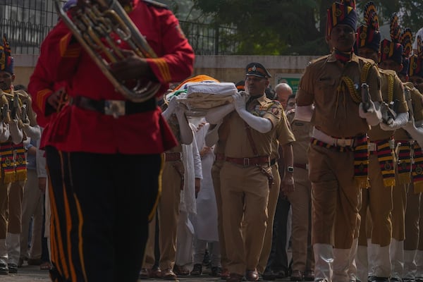 Police officers carry the body of Shyam Benegal, a renowned Indian filmmaker who passed away on Monday, during Benegal's funeral in Mumbai, India, Tuesday, Dec. 24, 2024. (AP Photo/Rafiq Maqbool)