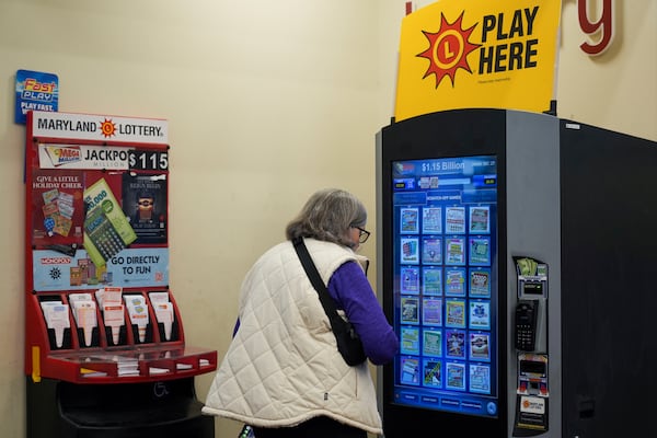 A person makes their lottery ticket selections on a self-serve terminal inside a gas station ahead of Friday's Mega Millions drawing of $1.15 billion, Thursday, Dec. 26, 2024, in Baltimore. (AP Photo/Stephanie Scarbrough)