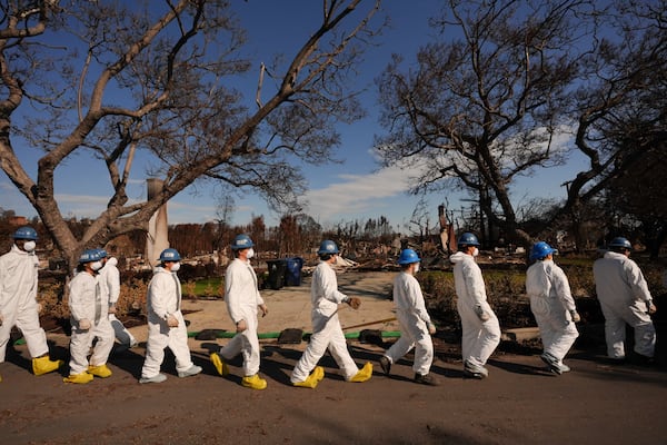 Members of California Conservation Corps work in the rubble of the Palisades Fire in the Pacific Palisades section of Los Angeles, Monday, Jan. 27, 2025. (AP Photo/Jae C. Hong)