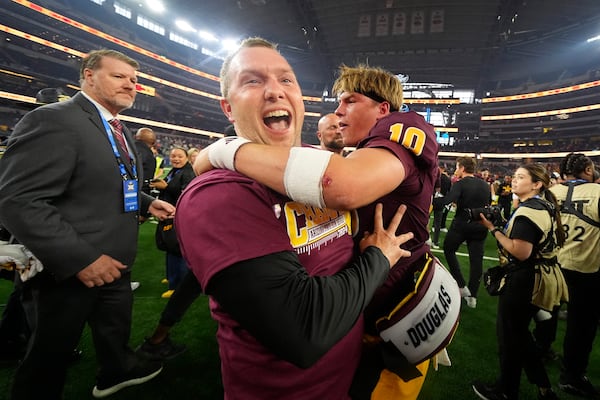 Ariona State head coach Kenny Dillingham, left, and quarterback Sam Leavitt, right, celebrate after the team's win in the Big 12 Conference championship NCAA college football game against Iowa State, in Arlington, Texas, Saturday Dec. 7, 2024. (AP Photo/Julio Cortez)