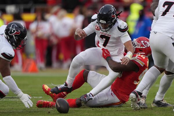 Houston Texans quarterback C.J. Stroud (7) fumbles as he is hit by Kansas City Chiefs defensive end Charles Omenihu, right, during the first half of an NFL football AFC divisional playoff game Saturday, Jan. 18, 2025, in Kansas City, Mo. (AP Photo/Charlie Riedel)