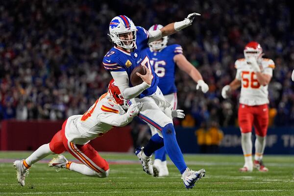 Buffalo Bills quarterback Josh Allen (17) slips past Kansas City Chiefs cornerback Nazeeh Johnson to score on a 26-yard run during the second half of an NFL football game Sunday, Nov. 17, 2024, in Orchard Park, N.Y. (AP Photo/Julia Demaree Nikhinson)