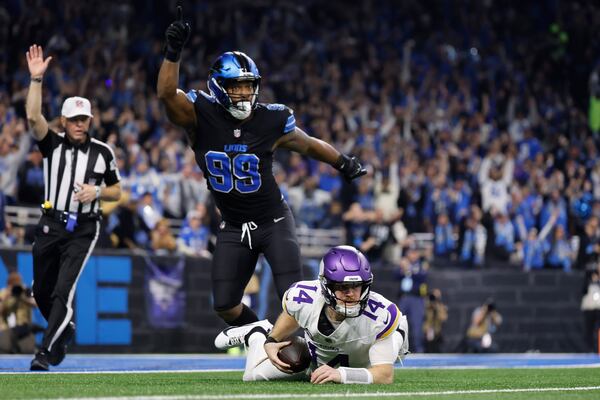 Minnesota Vikings quarterback Sam Darnold (14) is sacked by Detroit Lions defensive end Za'Darius Smith (99) during the first half of an NFL football game Sunday, Jan. 5, 2025, in Detroit. (AP Photo/Rey Del Rio)