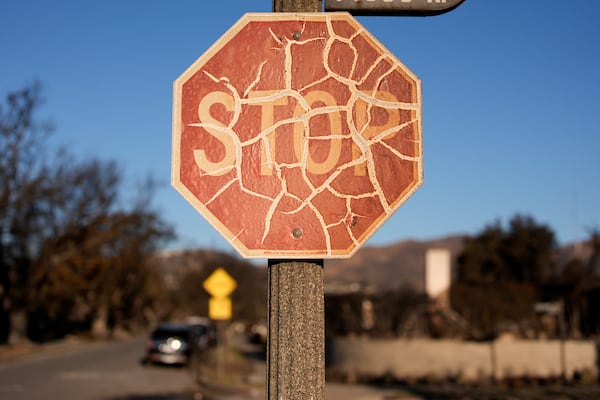 A stop sign is damaged in the aftermath of the Palisades Fire in the Pacific Palisades neighborhood of Los Angeles, Monday, Jan. 13, 2025. (AP Photo/John Locher)