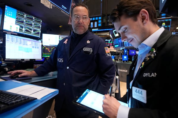 Specialist Anthony Matesic, left, works at his post on the floor of the New York Stock Exchange, Wednesday, Dec. 18, 2024. (AP Photo/Richard Drew)