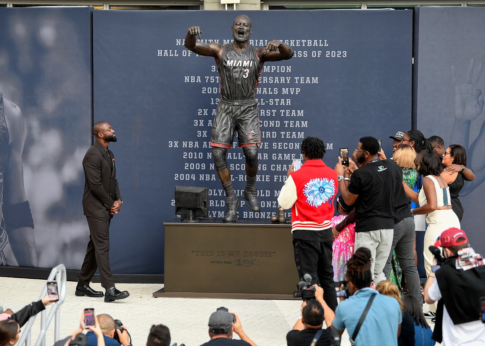 Former Miami Heat NBA basketball player Dwyane Wade, upper left, looks at a bronze statue of himself during a statue unveiling ceremony outside the Kaseya Center, Sunday, Oct. 27, 2024, in Miami, Fla. (AP Photo/Michael Laughlin)