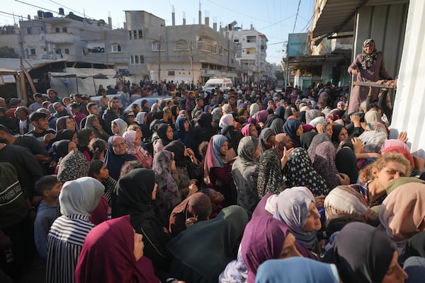 A crowd gathers in front of a bakery to get a share of bread in Deir al-Balah, Gaza Strip, Thursday Nov. 21, 2024. Some bakeries in the Gaza Strip have reopened Thursday morning after shuttering for several days due to a flour shortage and lack of food aid.(AP Photo/Abdel Kareem Hana)