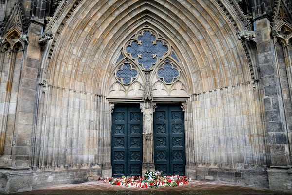 Flowers and candles laid down in front of the Magdeburg Cathedra, after a car drove into a crowd of a Christmas Mark on Friday evening, in Magdeburg, Germany, Sunday, Dec. 22, 2024. (AP Photo/Ebrahim Noroozi)