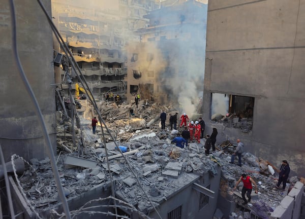 Rescue workers and people search for victims at the site of an Israeli airstrike that hit central Beirut, Lebanon, Saturday, Nov. 23, 2024. (AP Photo/Hassan Ammar)