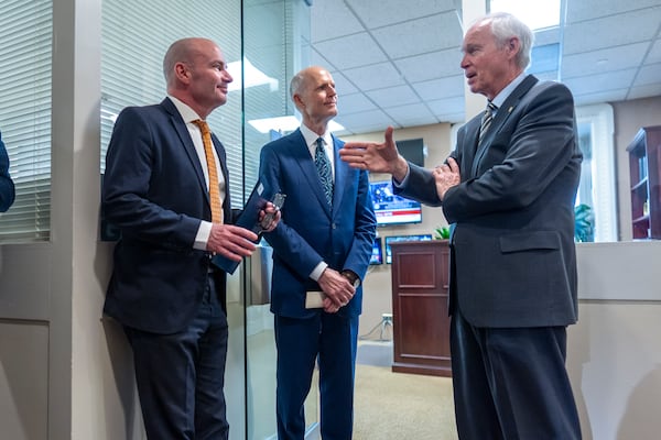 Sen. Mike Lee, R-Utah, Sen. Rick Scott, R-Fla., and Sen. Ron Johnson, R-Wis., confer before joining other conservative Republicans to complain to reporters about the interim spending bill being crafted to avoid a shutdown of federal agencies, at the Capitol in Washington, Wednesday, Dec. 18, 2024. (AP Photo/J. Scott Applewhite)