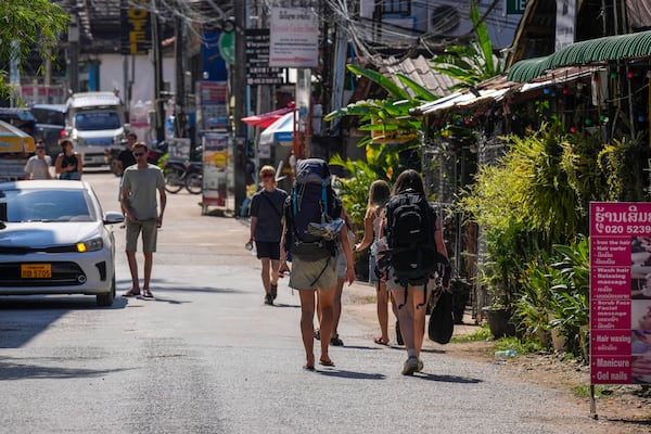 Backpacker foreign tourists roam around in Vang Vieng, Laos, Friday, Nov. 22, 2024. (AP Photo/Anupam Nath)