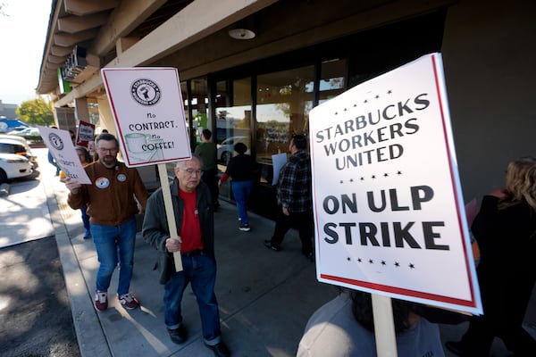 Starbuck workers picket outside of a closed Starbucks on Friday, Dec. 20, 2024, in Burbank, Calif. (AP Photo/Damian Dovarganes)