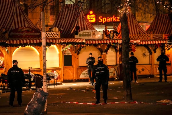 Security guards stand in front of a cordoned-off Christmas Market after a car crashed into a crowd of people, in Magdeburg, Germany, Saturday early morning, Dec. 21, 2024. (AP Photo/Ebrahim Noroozi)