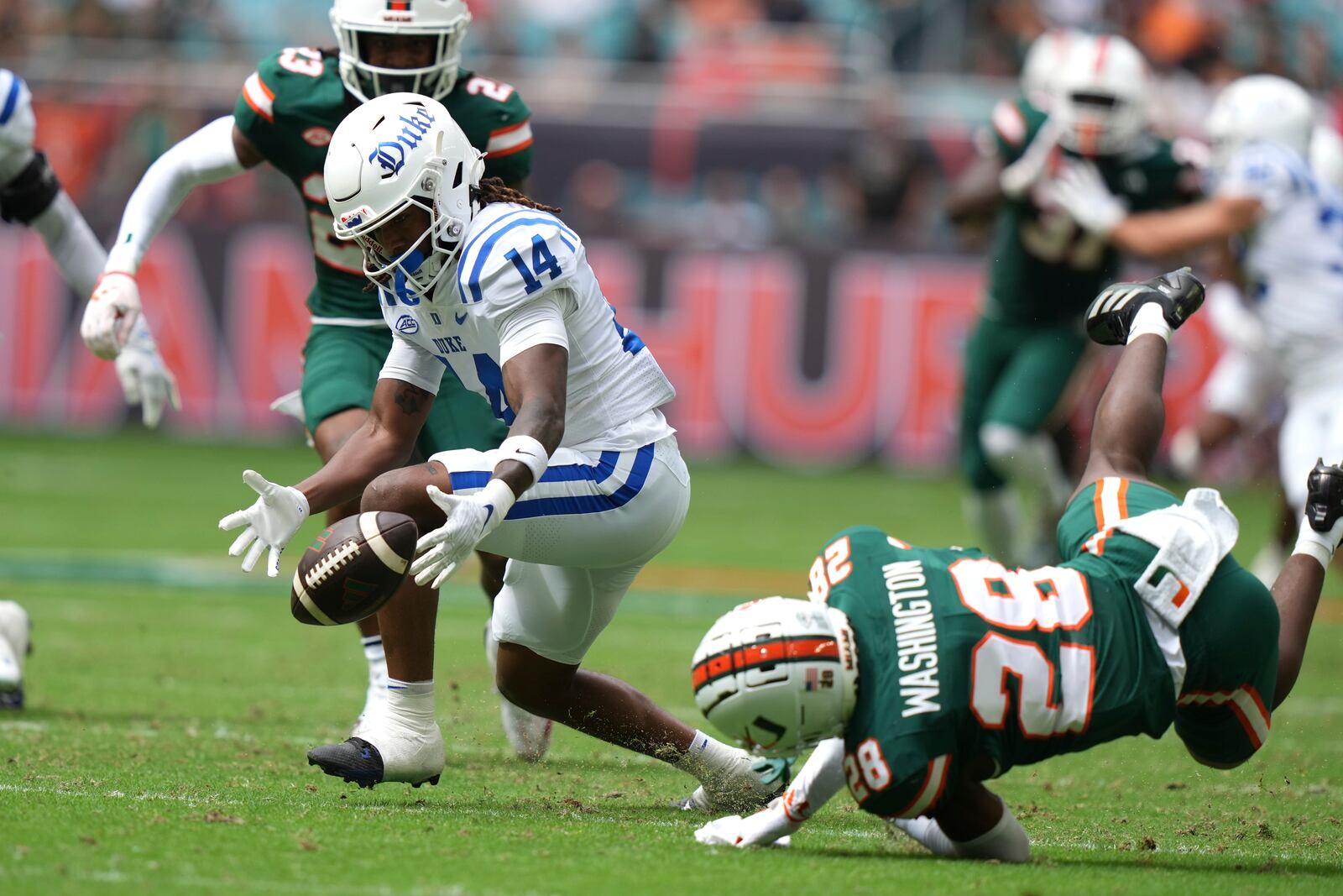 Duke wide receiver Que'Sean Brown (14) bobbles the ball as Miami defensive back Robby Washington (28) defends during the first half of an NCAA college football game, Saturday, Nov. 2, 2024, in Miami Gardens, Fla. (AP Photo/Lynne Sladky)