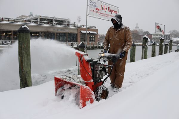 Tony Savage, who works for the city of Annapolis, clears snow along the City Dock in Annapolis, Md., Monday, Jan. 6, 2025. (AP Photo/Brian Witte)