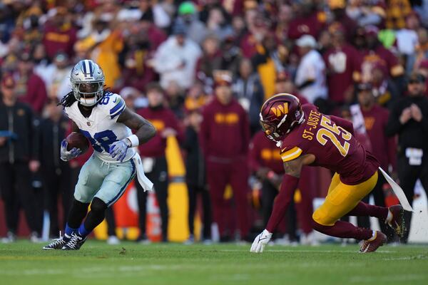 Dallas Cowboys wide receiver CeeDee Lamb (88) runs with the football as Washington Commanders cornerback Benjamin St-Juste (25) tries to tackle during the first half of an NFL football game, Sunday, Nov. 24, 2024, in Landover, Md. (AP Photo/Stephanie Scarbrough)