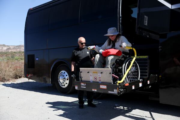 Jennifer Piatek, a planetary geologist at Central Connecticut State University, is helped off the bus during an accessible field trip to the San Andreas Fault organized by the International Association of Geoscience Diversity Thursday, Sept. 26, 2024, in San Bernadino, Calif. (AP Photo/Ryan Sun)