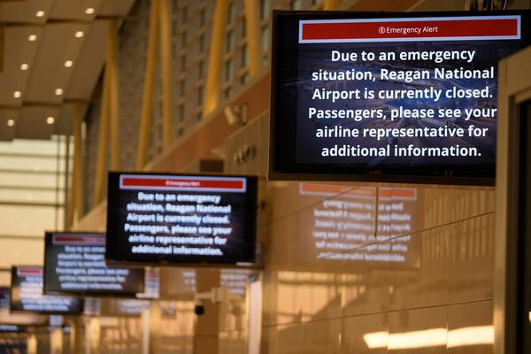 Signs display an "Emergency Alert" at Ronald Reagan Washington National Airport, Thursday, Jan. 30, 2025, in Arlington, Va. (AP Photo/Mark Schiefelbein)