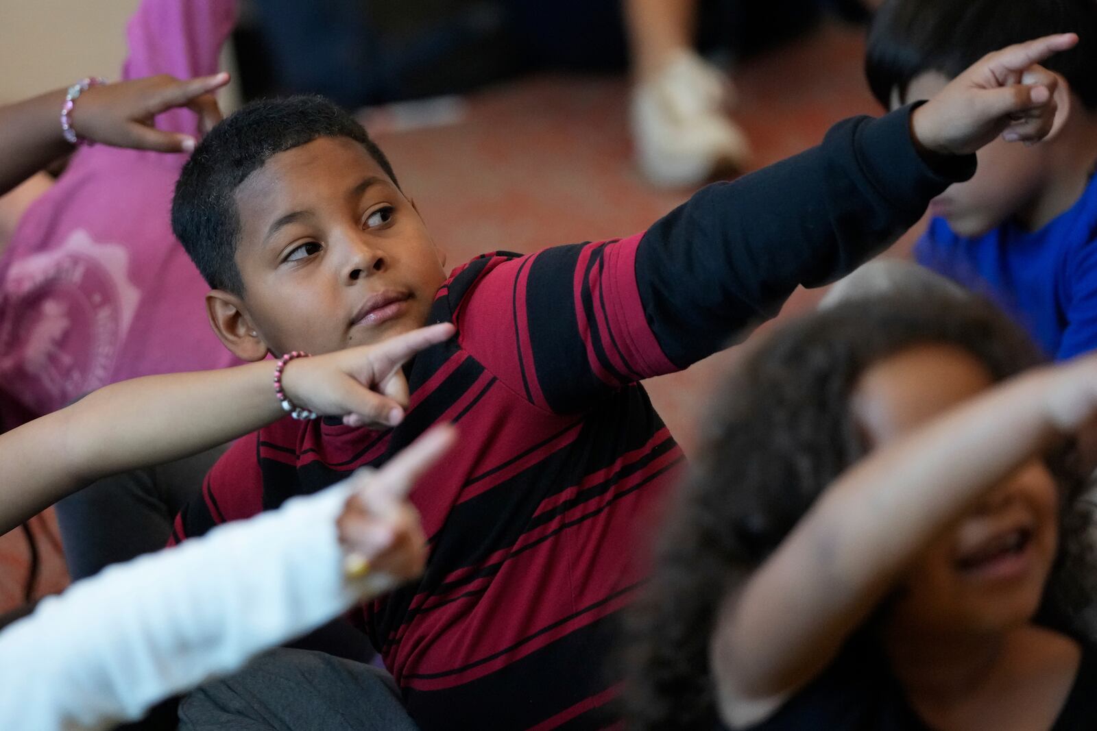 Dylan Martínez-Ramírez, center, participates in an English Language Development class activity Thursday, Aug. 29, 2024, in Aurora, Colo. (AP Photo/Godofredo A. Vásquez)