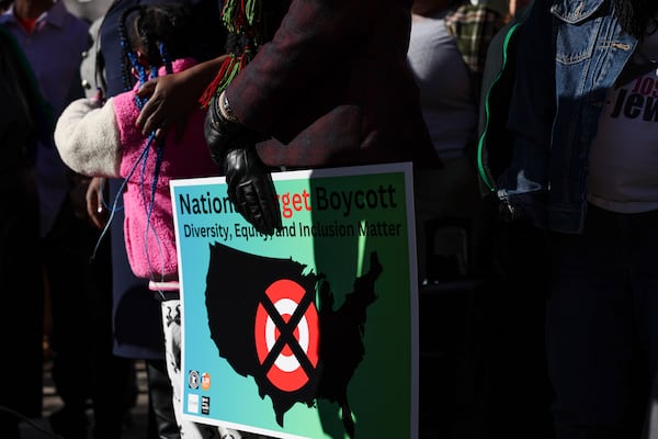 A community member holds a sign calling for a national boycott of Target stores during a news conference outside Target Corporation's headquarters Thursday, Jan. 30, 2025, in Minneapolis, Minn. (AP Photo/Ellen Schmidt)