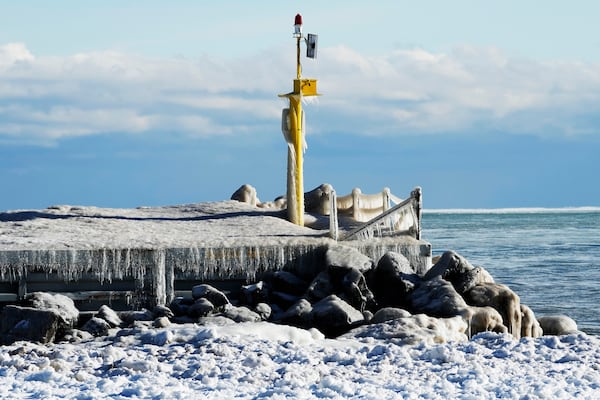 A harbor light is covered by ice at the church street power boat ramp on during cold weather in Evanston, Ill., Wednesday, Jan. 8, 2025. (AP Photo/Nam Y. Huh)