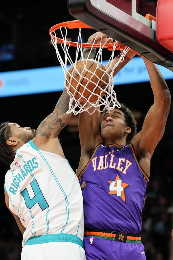 Phoenix Suns center Oso Ighodaro, right, dunks against Charlotte Hornets center Nick Richards, left, during the second half of an NBA basketball game Sunday, Jan. 12, 2025, in Phoenix. (AP Photo/Ross D. Franklin)