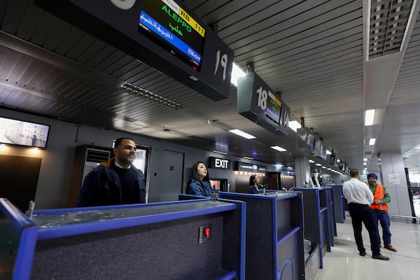 Employees stand at check-in counters as the airport reopens for domestic flights in Damascus, Syria, Wednesday, Dec. 18, 2024. (AP Photo/Omar Sanadiki)