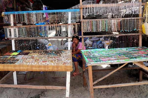 York Klathale waits for customers to buy souvenirs at Moken village at Surin Islands in Phang Nga Province, Thailand, Wednesday, Dec. 11, 2024. (AP Photo/Sakchai Lalit)